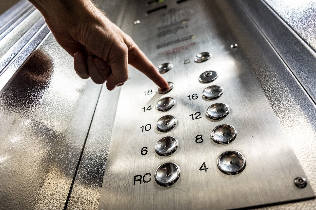 エレベーターの階数ボタンを押す手