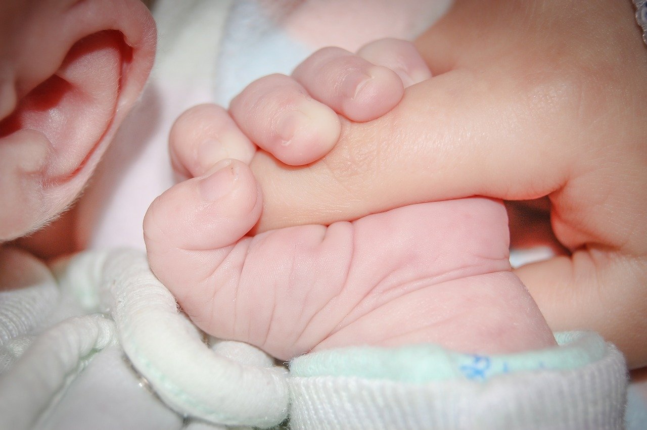 親の人差し指を握る赤ちゃんの小さな手