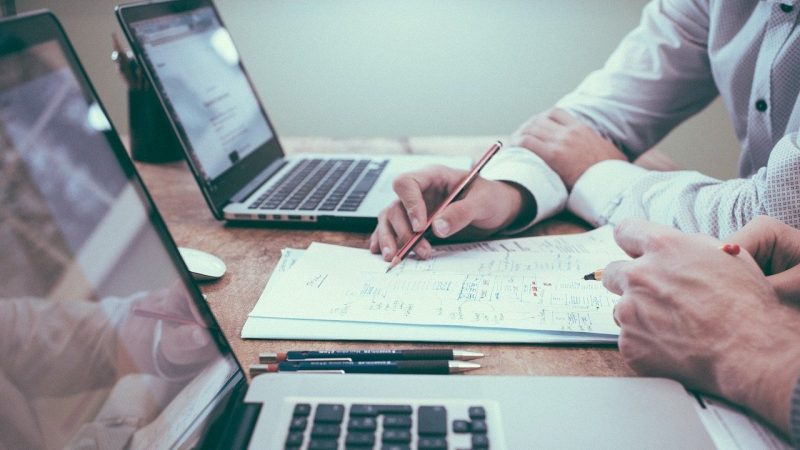 PCの前で会話する2人の男性